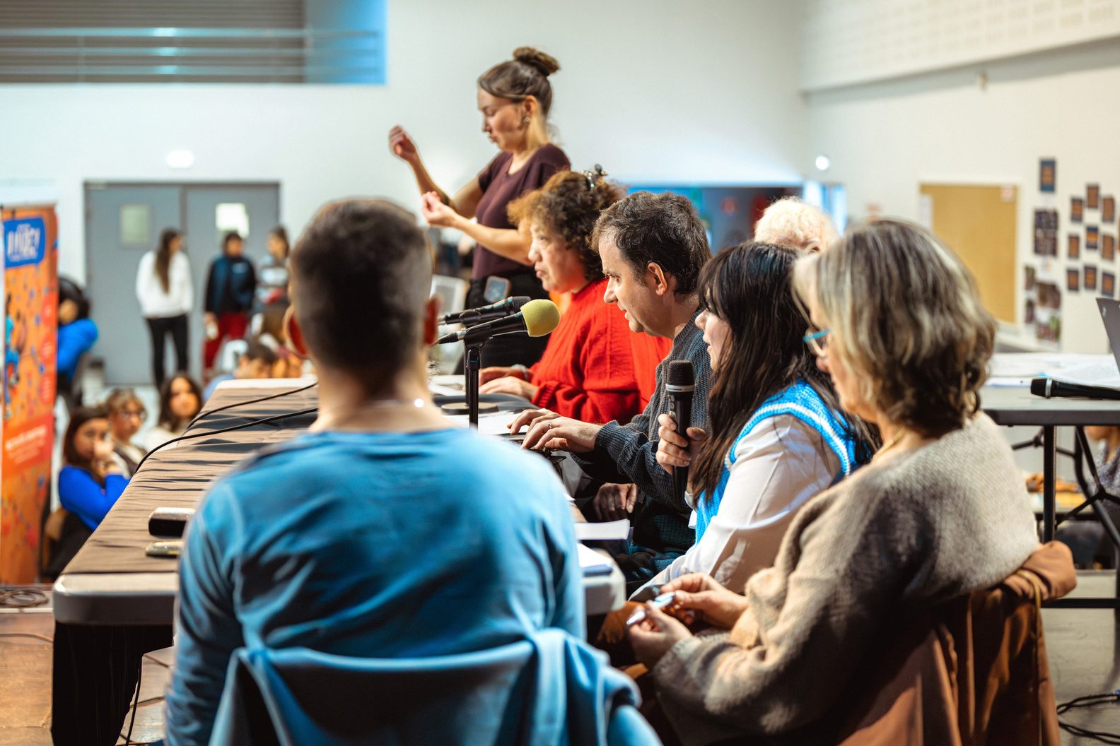 Des participants assis autour d'une table prennent la parole au micro lors d'une rencontre Handiciviq.